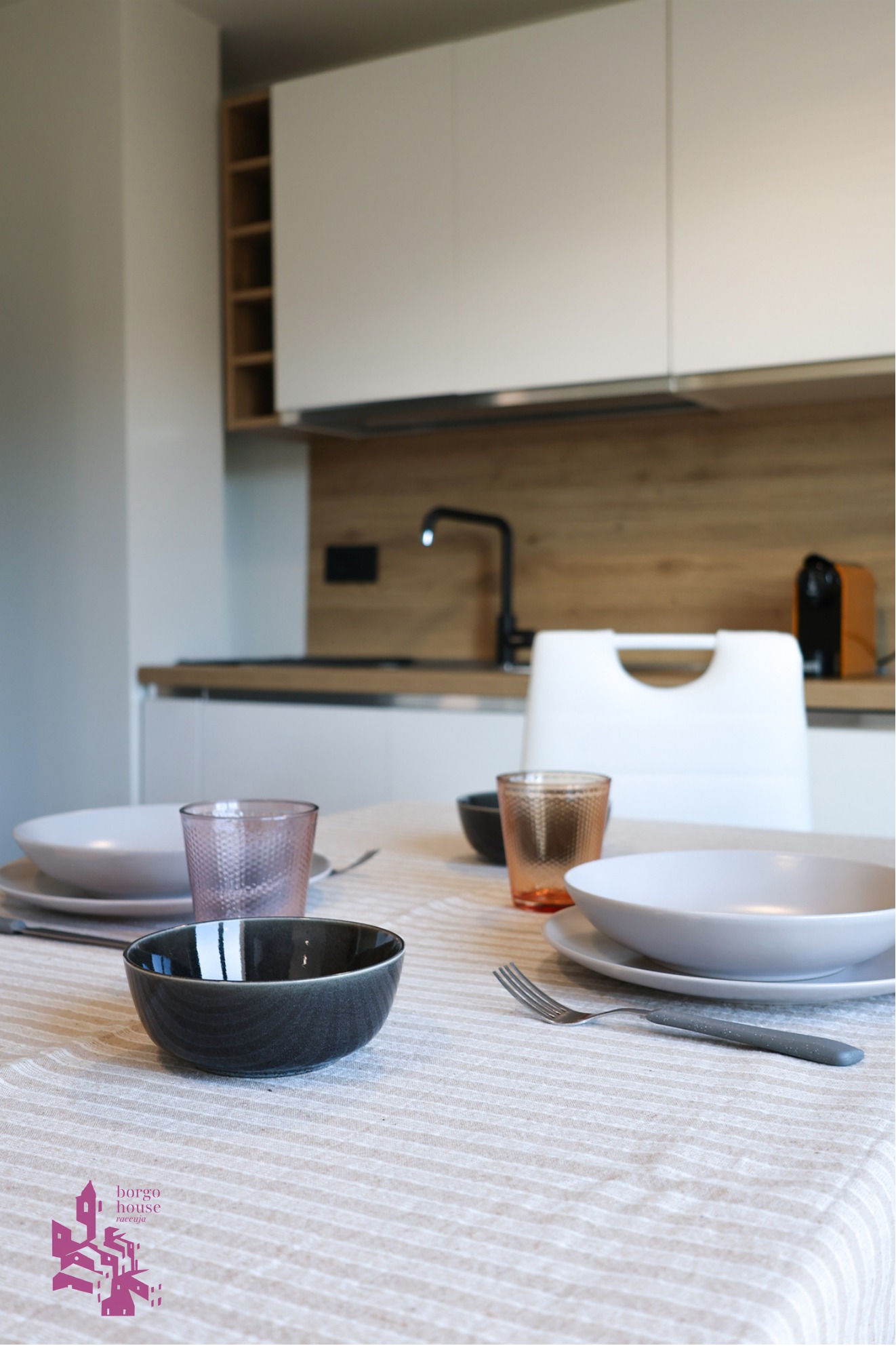 Zona pranzo con cucina sullo sfondo a Borgo House Raccuja