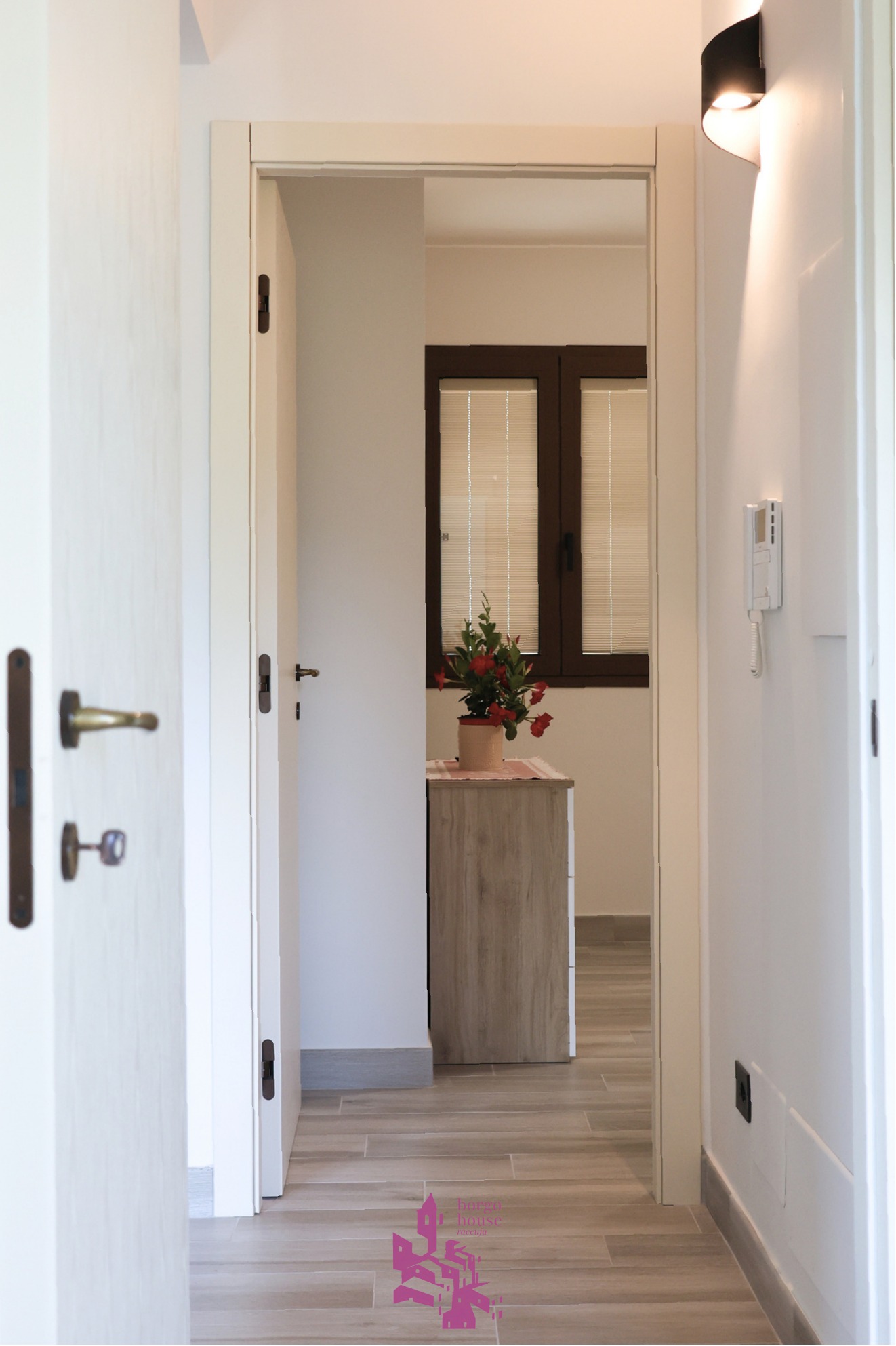Corridoio interno di Borgo House con porte e finitura luminosa
