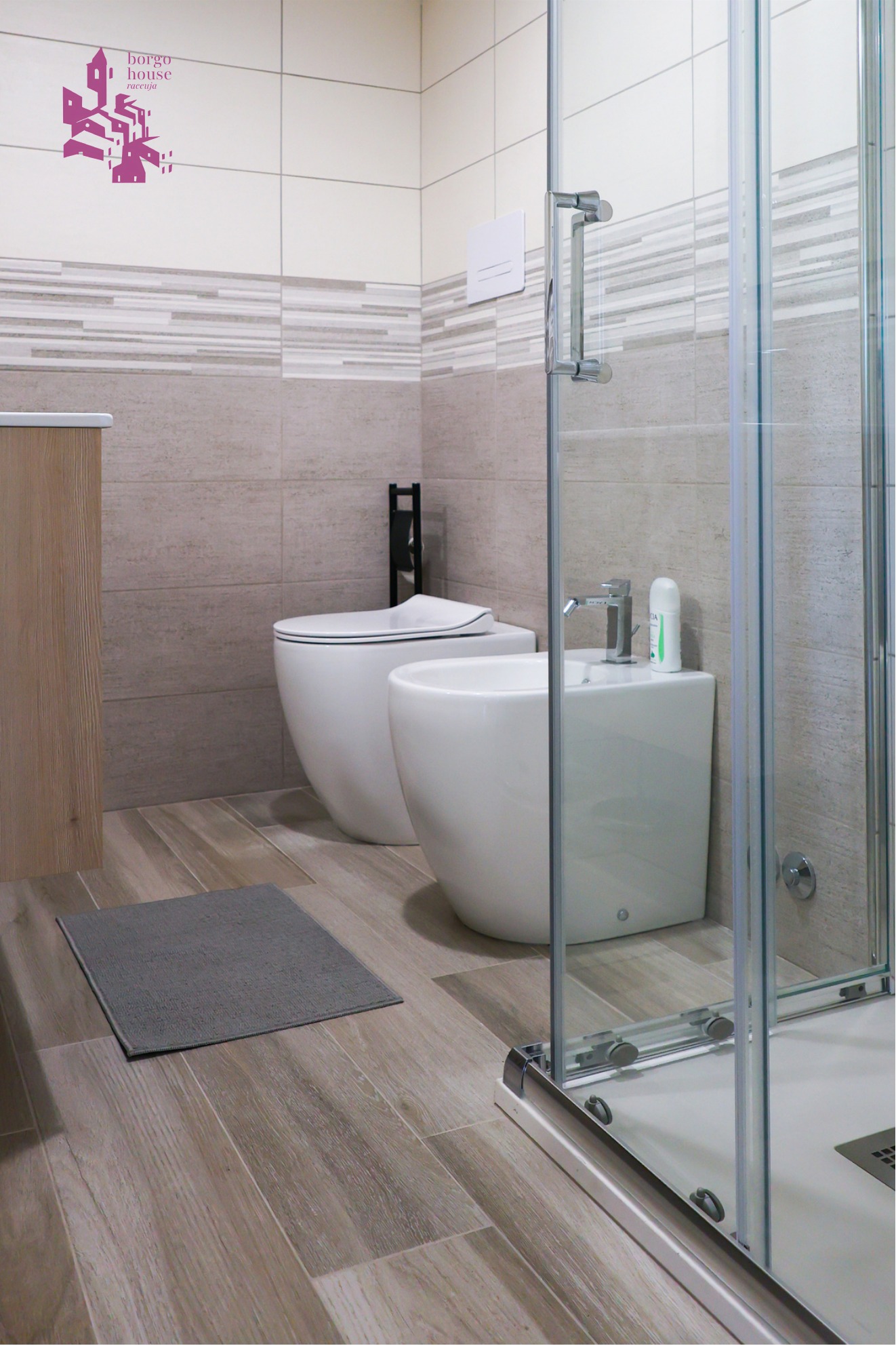 Bagno moderno di Borgo House con doccia in vetro e pavimento effetto legno